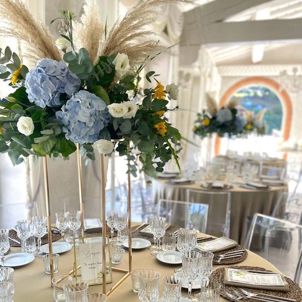 Allestimento matrimonio in sala con composizioni su supporti dorati – Fiori nel Tempo